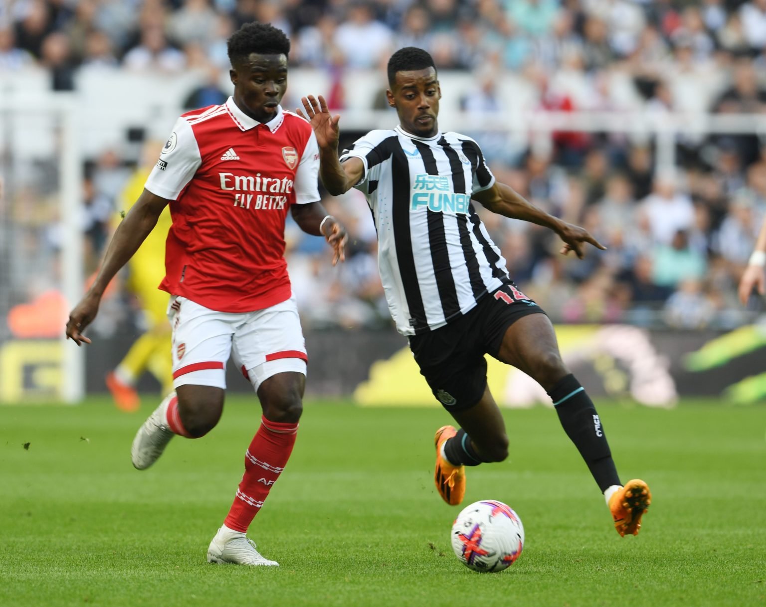 Bukayo Saka of Arsenal takes on Alexander Isak of Newcastle during the Premier League match between Newcastle United and Arsenal FC at St. James Pa...