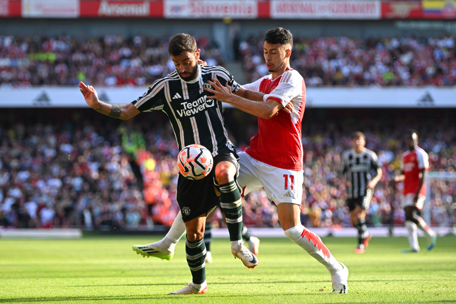 Bruno Fernandes of Manchester United is challenged by Gabriel Martinelli of Arsenal during the Premier League match between Arsenal FC and Manchest...