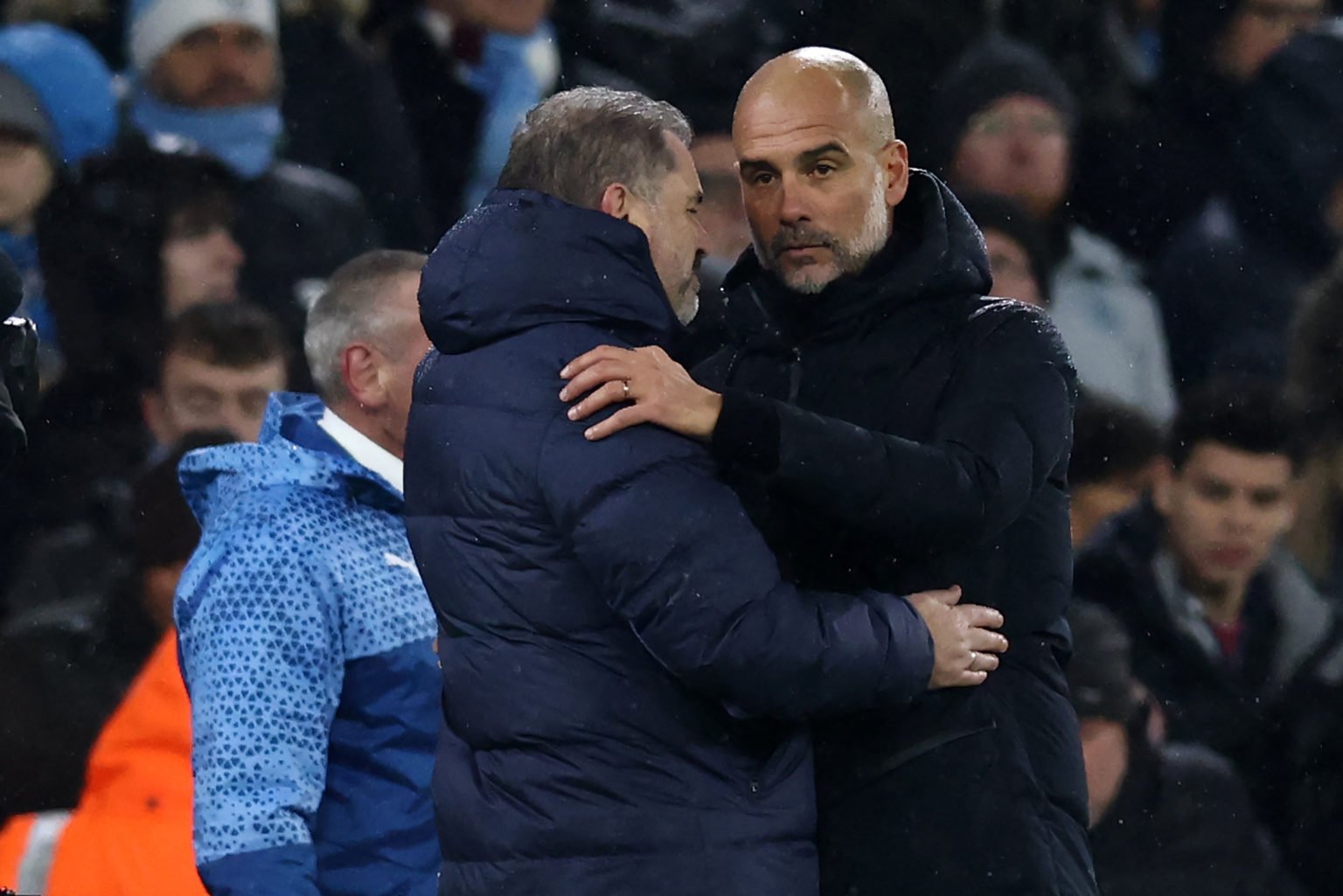 Tottenham Hotspur's Greek-Australian Head Coach Ange Postecoglou (L) and Manchester City's Spanish manager Pep Guardiola (R) embrace after the Engl...