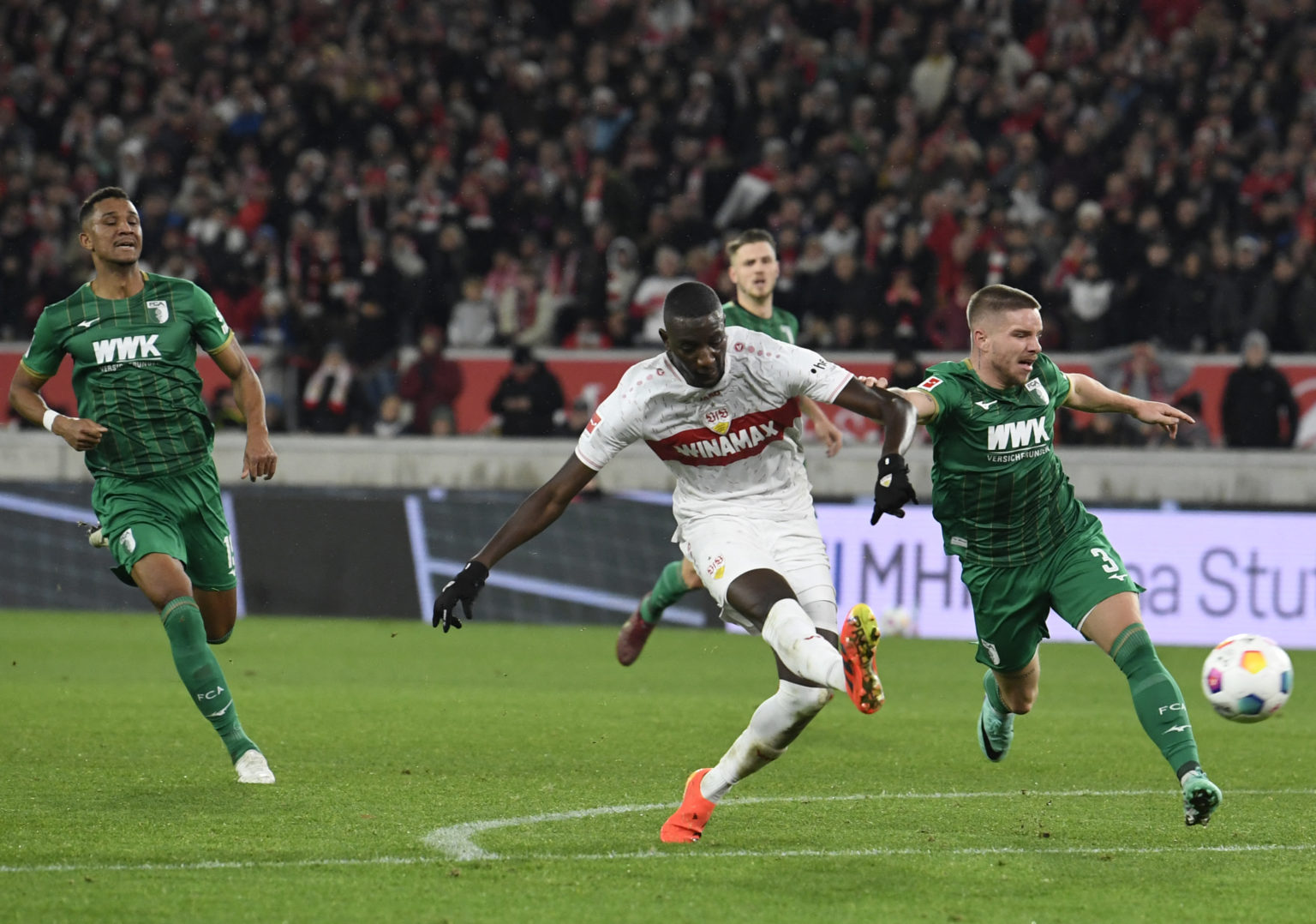 Stuttgart's Guinean forward #09 Serhou Guirassy scores the 2-0 past Augsburg's Danish defender #03 Mads Pedersen (R)  during the German first divis...