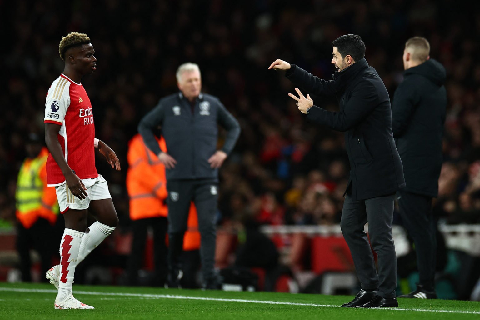 Arsenal's Spanish manager Mikel Arteta (R) speaks to Arsenal's English midfielder #07 Bukayo Saka during the English Premier League football match ...