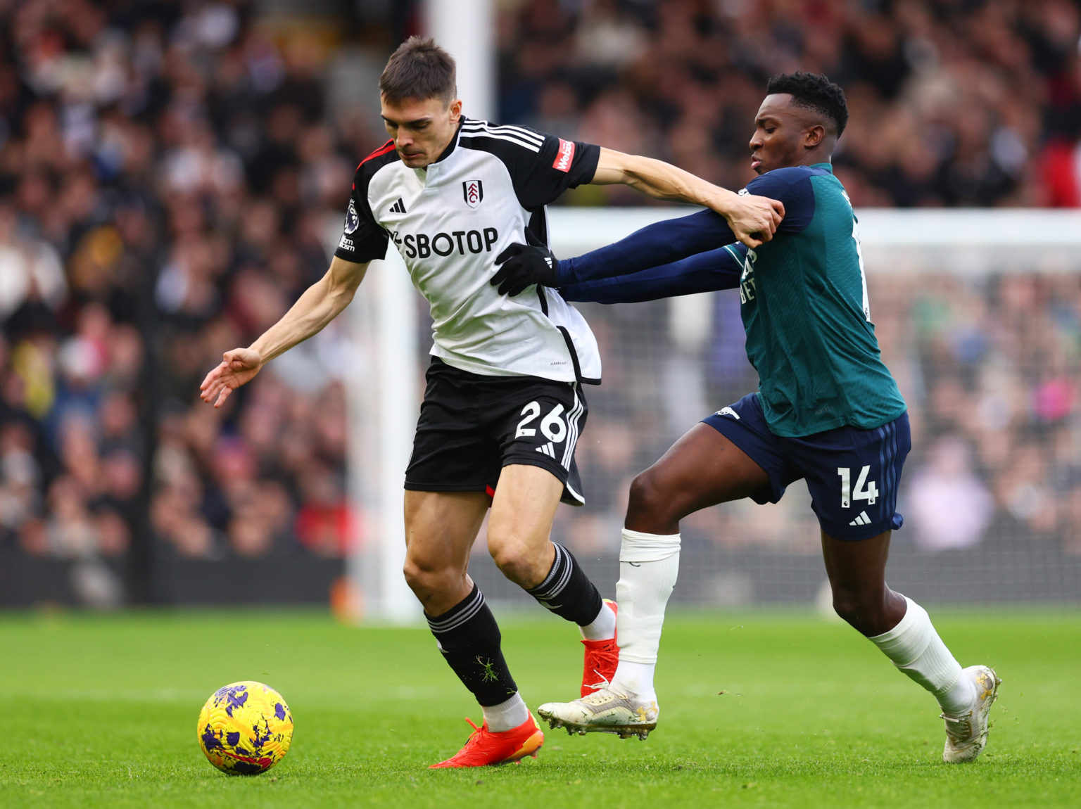 Joao Palhinha of Fulham is challenged by Eddie Nketiah of Arsenal during the Premier League match between Fulham FC and Arsenal FC at Craven Cottag...