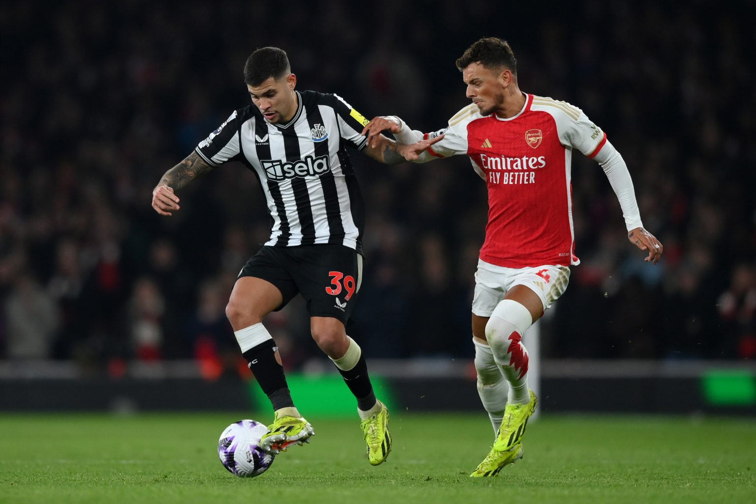 Bruno Guimaraes of Newcastle United holds off Ben White of Arsenal  during the Premier League match between Arsenal FC and Newcastle United at Emir...