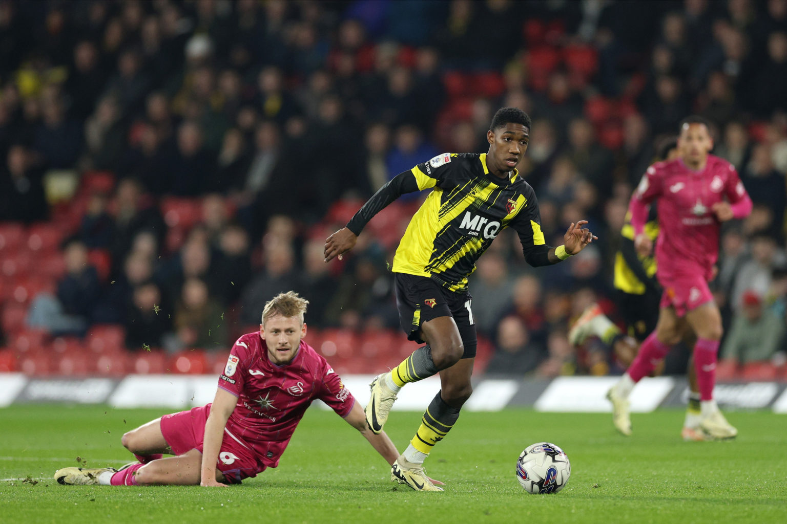 Yaser Asprilla of Watford breaks with the ball from Harry Darling of Swansea City during the Sky Bet Championship match between Watford and Swansea...