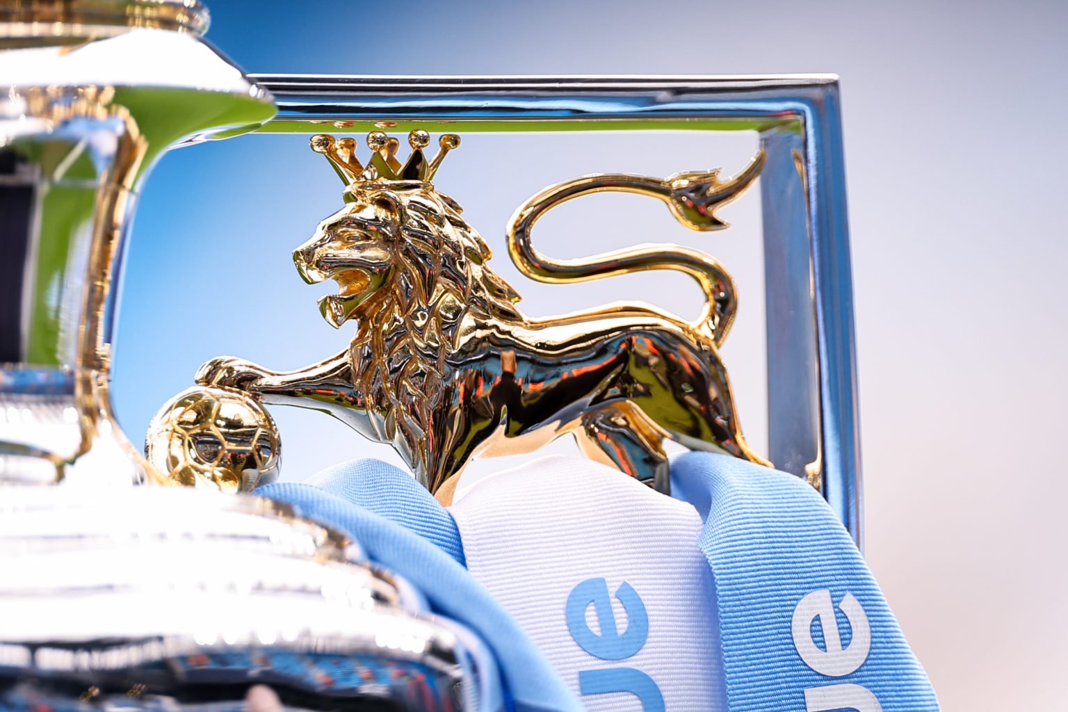 Detail of the lion on the Premier League trophy seen with blue and white ribbons on it ahead of the Premier League match between Manchester City an...