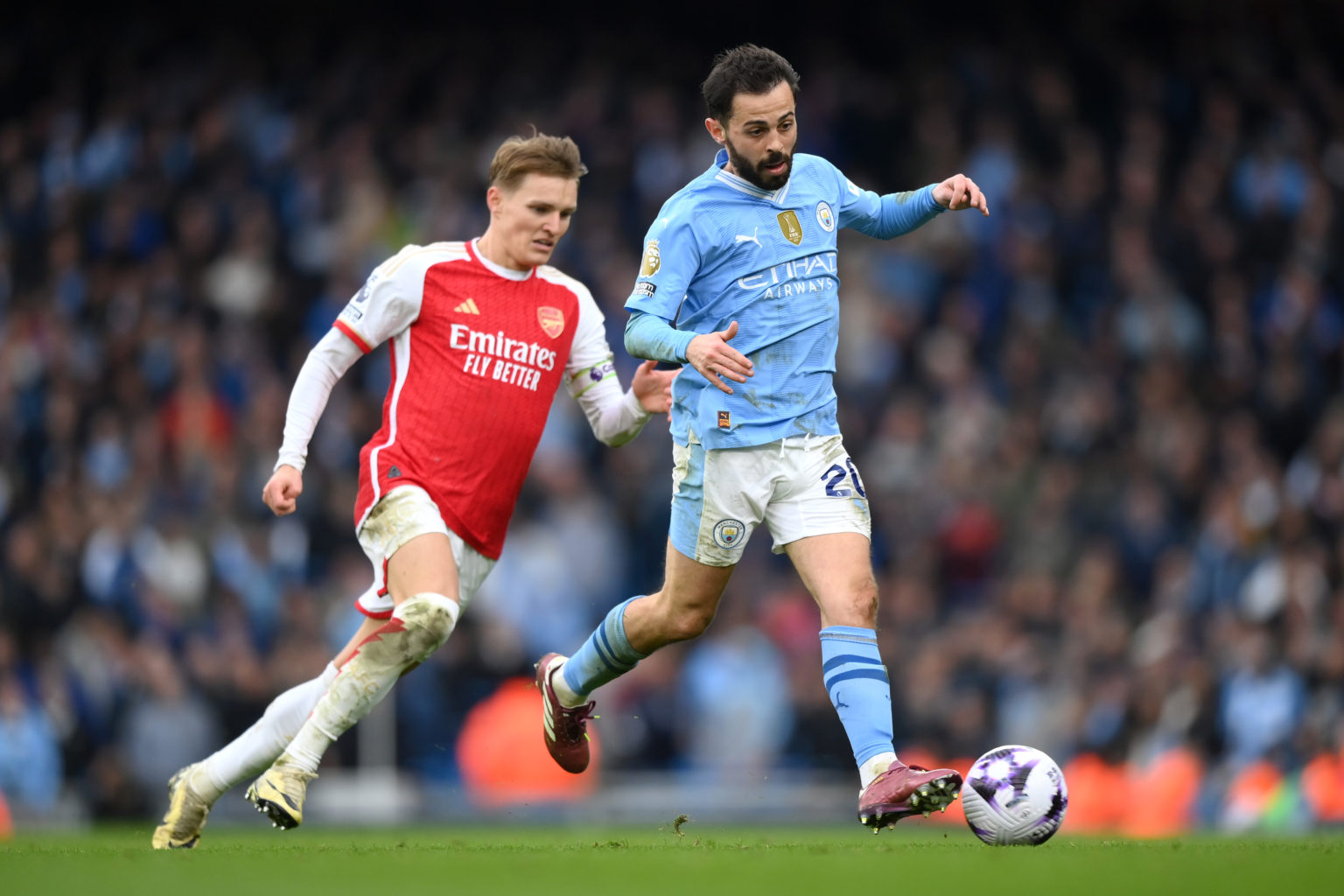 Bernardo Silva of Manchester City takes on Martin Odegaard of Arsenal during the Premier League match between Manchester City and Arsenal FC at Eti...