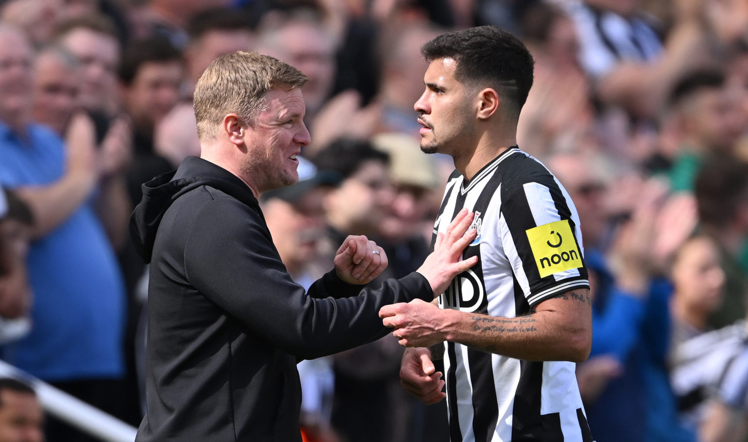 Newcastle United player Bruno Guimaraes and head coach Eddie Howe share a joke after Guimaraes is Substituted during the Premier League match betwe...