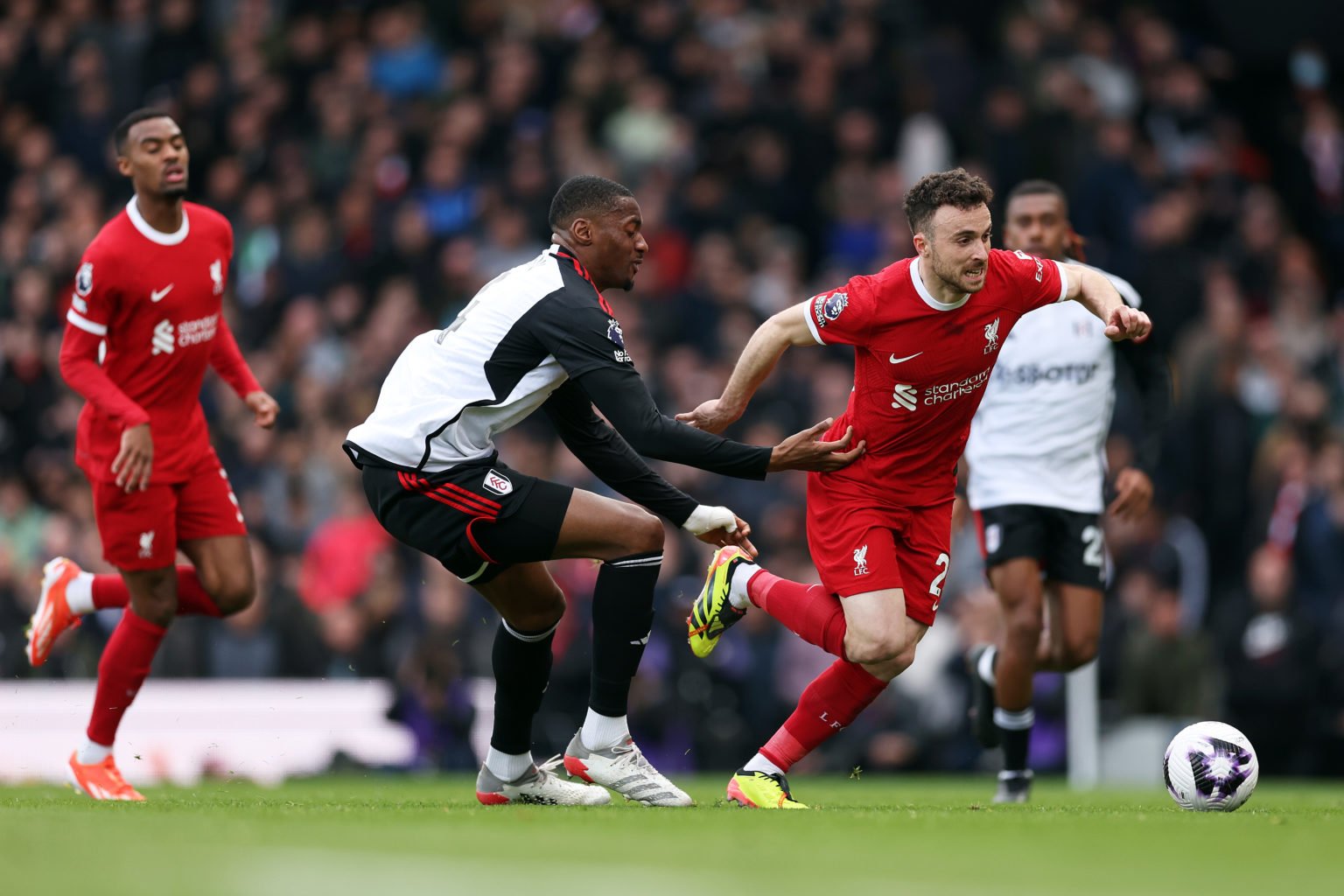 Diogo Jota of Liverpool is challenged by Tosin Adarabioyo of Fulham during the Premier League match between Fulham FC and Liverpool FC at Craven Co...