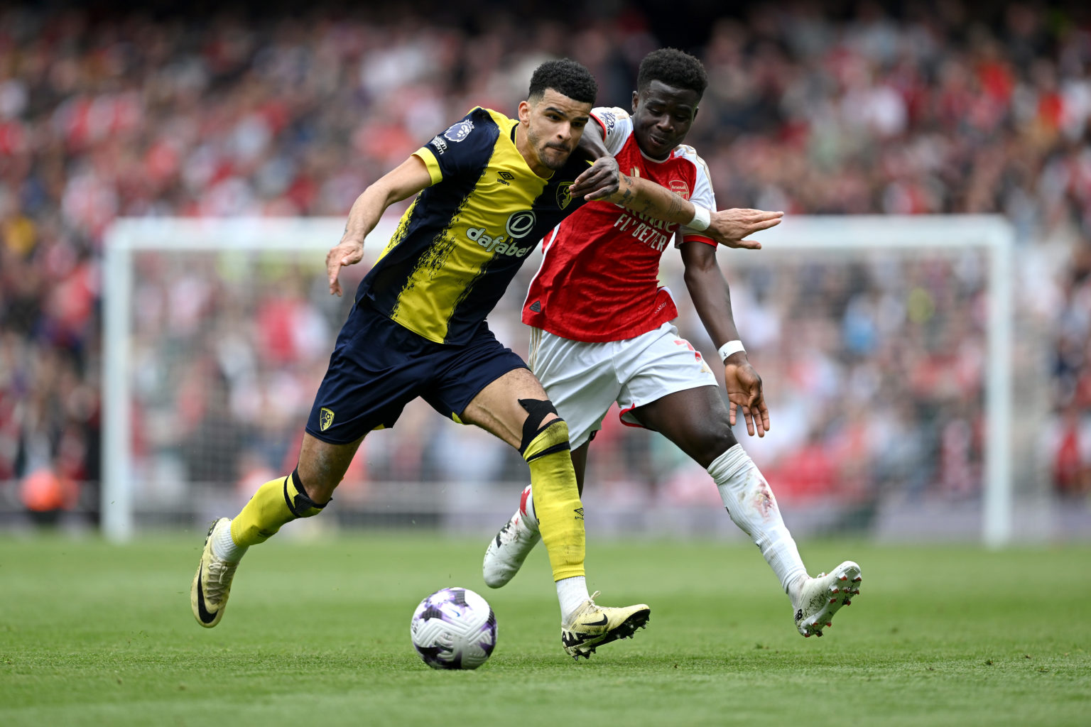 Dominic Solanke of AFC Bournemouth is challenged by Bukayo Saka of Arsenal during the Premier League match between Arsenal FC and AFC Bournemouth a...