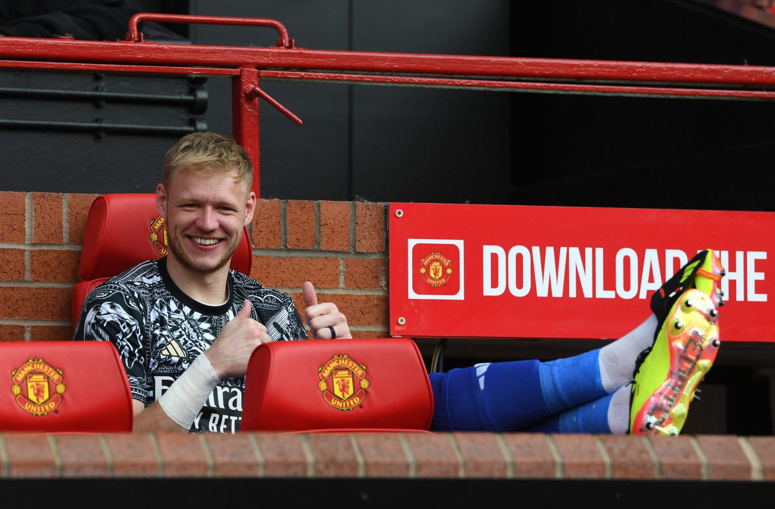 Aaron Ramsdale of Arsenal gestures a thumbs up as he poses for a photograph whilst sitting on the bench prior to the Premier League match between M...