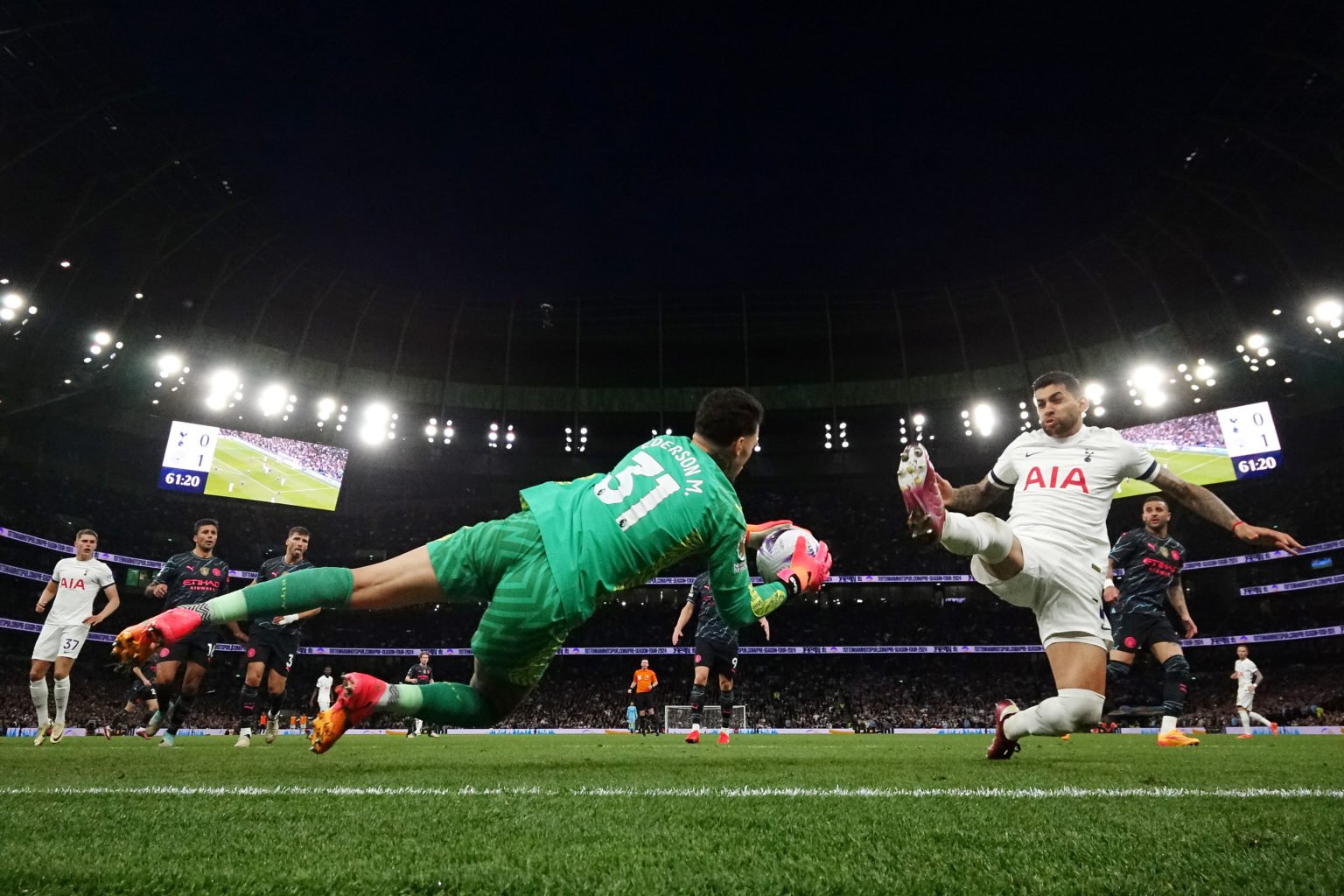 Cristian Romero of Tottenham Hotspur fouls Ederson of Manchester City, resulting in a yellow card leading to a injury for Ederson during the Premie...