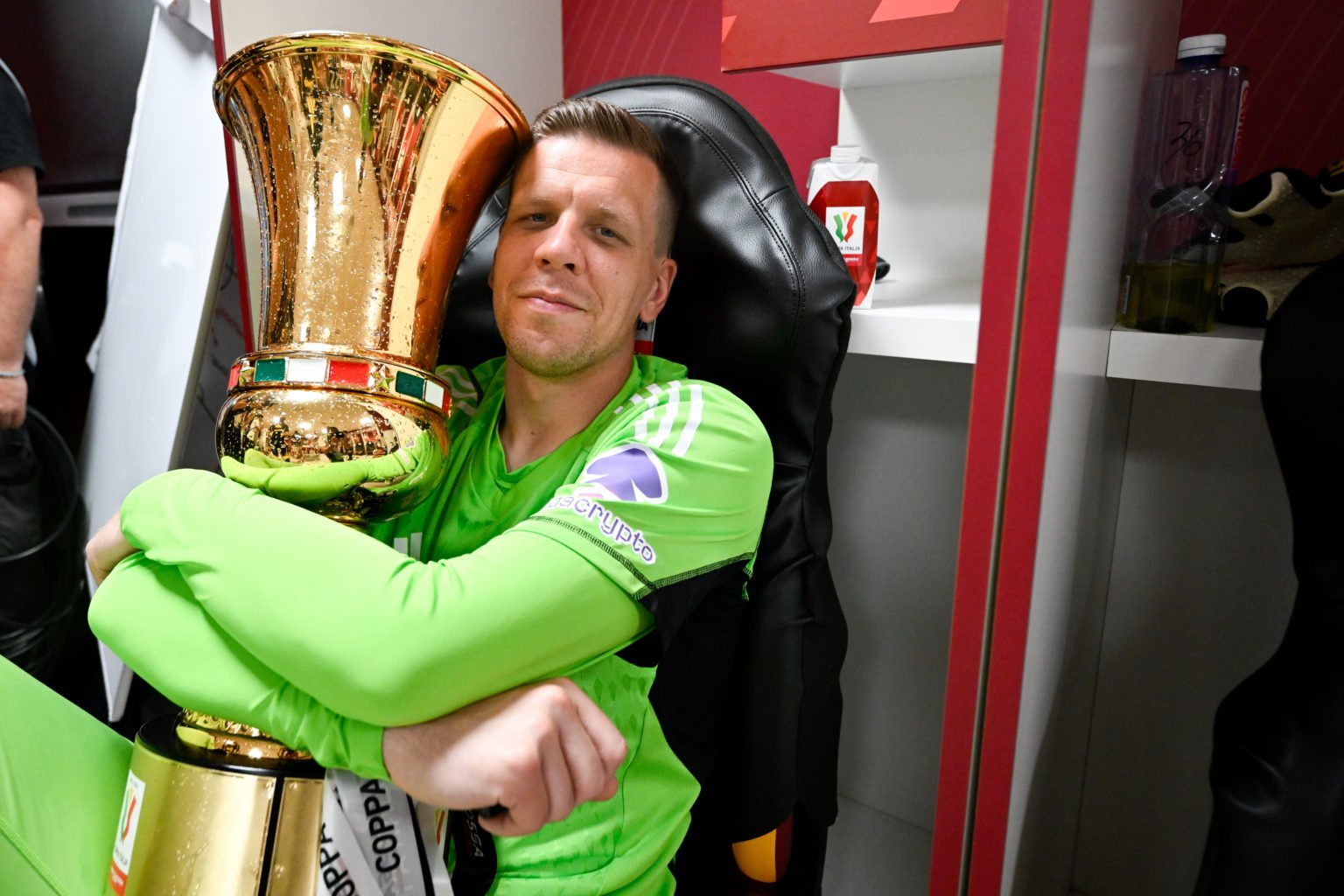 Juventus goalkeeper Wojciech Szczesny celebrates victory with the trophy in the dressing room after the Coppa Italia final match between Atalanta B...