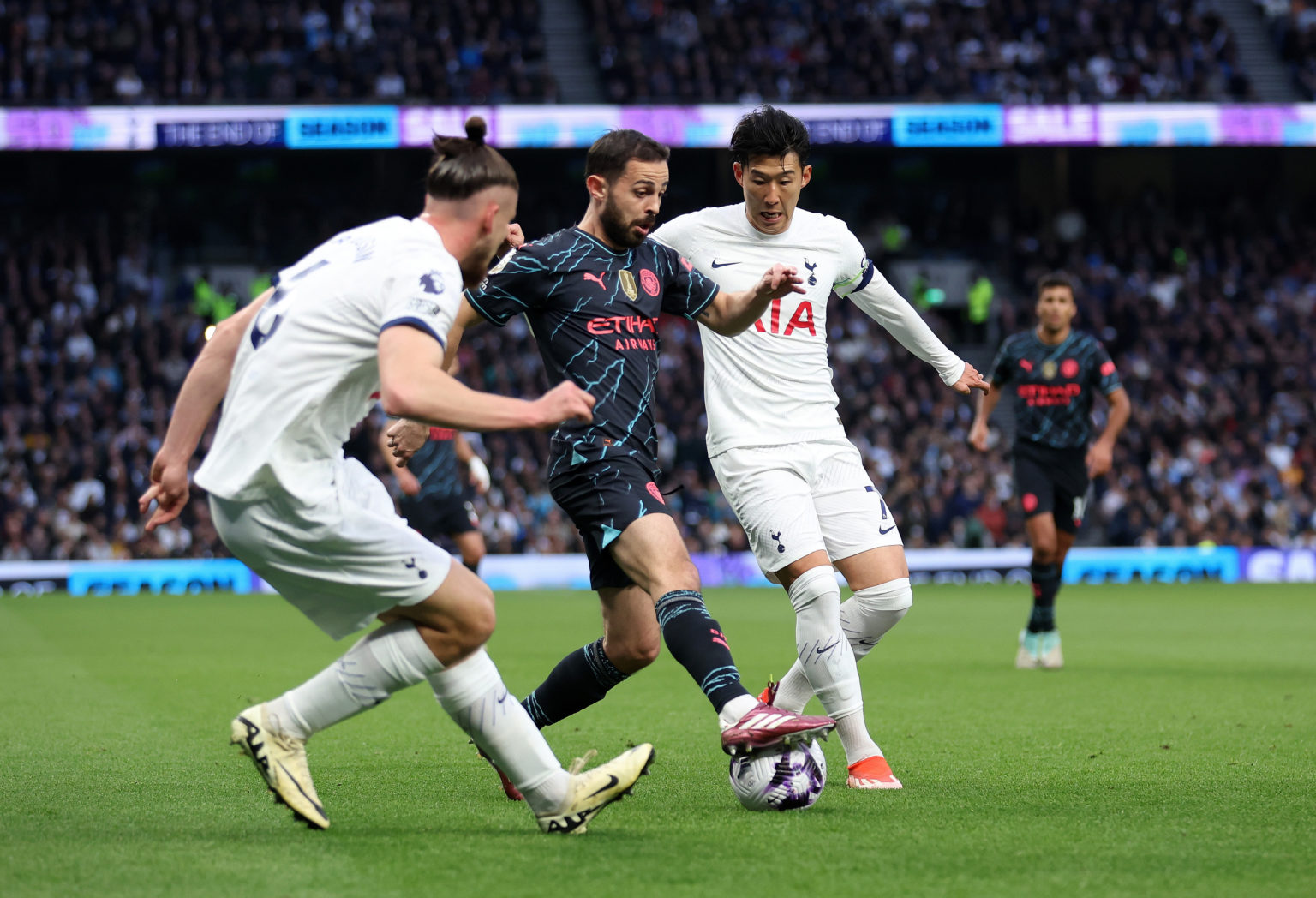 Bernardo Silva of Manchester City is tackled by Son Heung-Min of Tottenham Hotspur and and Radu Dragusin of Tottenham Hotspur  during the Premier L...