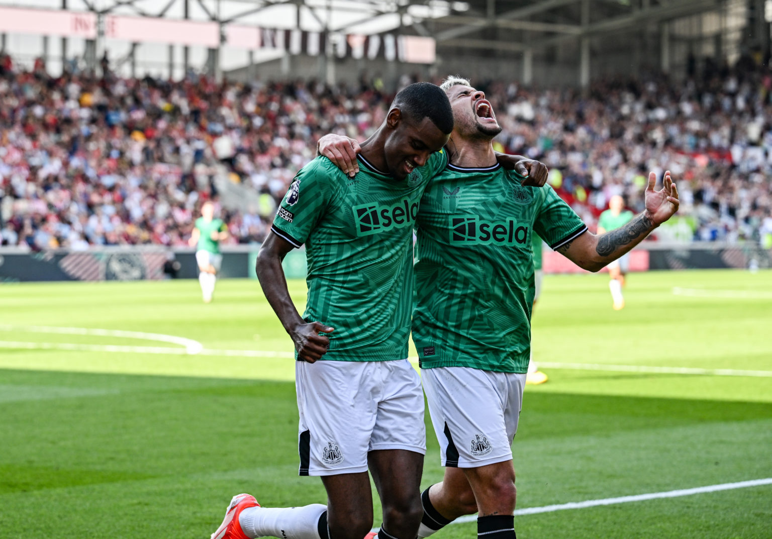 Alexander Isak of Newcastle United (14) celebrates with teammate Bruno Guimaraes after scoring the third goalduring the Premier League match betwee...