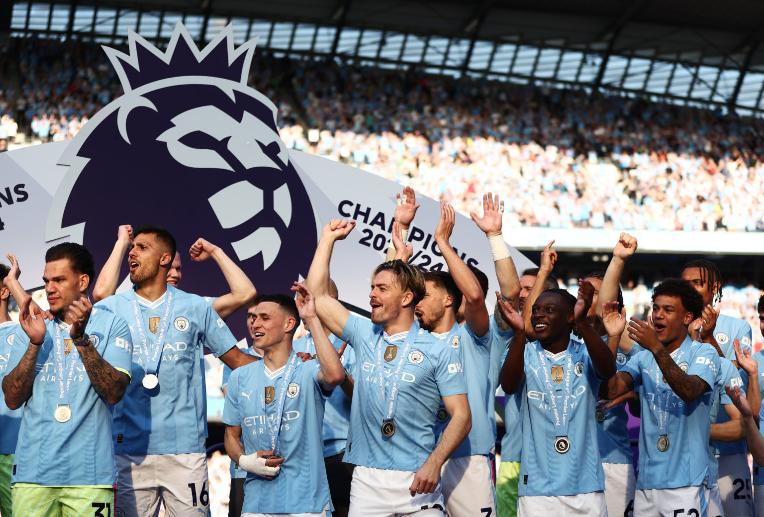 Sergio Gomez, Rodri, Phil Foden, Jack Grealish, Jeremy Doku and Oscar Bobb of Manchester City celebrate on the winners podium with their winners me...