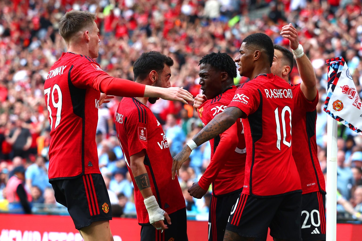 Kobbie Mainoo of Manchester United is mobbed by his team-mates after scoring his side's second goal during the Emirates FA Cup Final match between ...