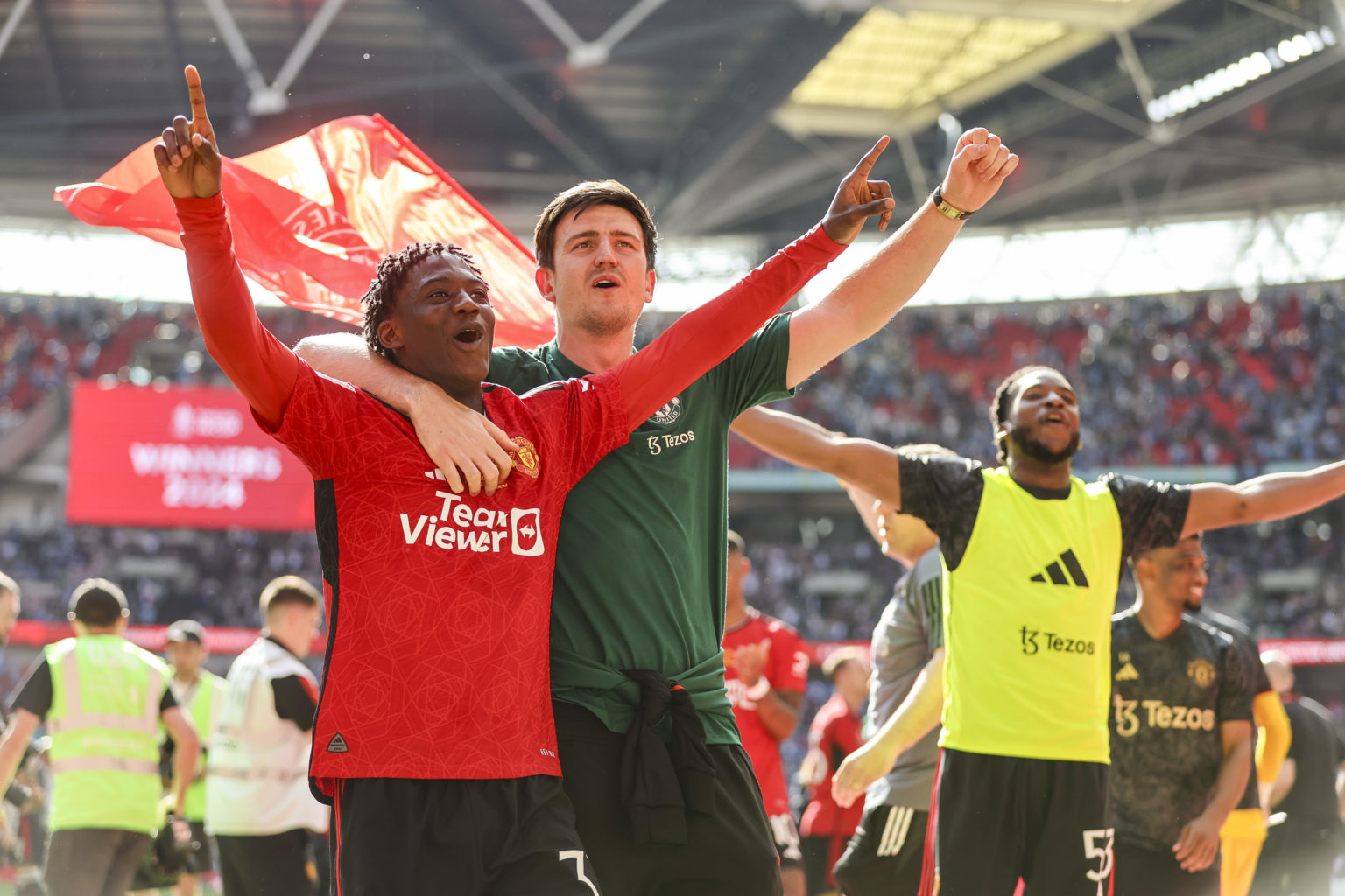 Goalscorer Kobbie Mainoo with injured team-mate Harry Maguire of Manchester United after their sides 2-1 win during the Emirates FA Cup Final match...