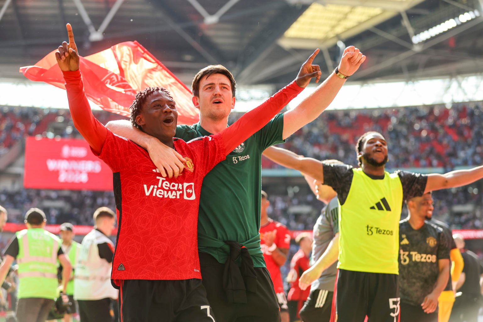 Goalscorer Kobbie Mainoo with injured team-mate Harry Maguire of Manchester United after their sides 2-1 win during the Emirates FA Cup Final match...