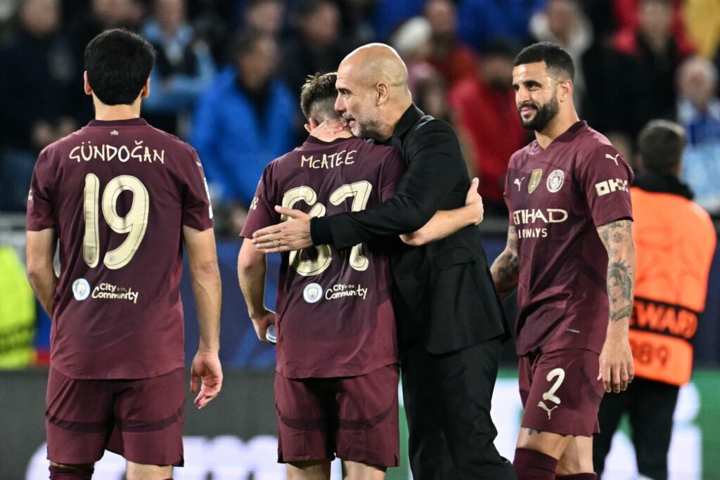 Manchester City's Spanish manager Pep Guardiola (2R) celebrates with Manchester City's English midfielder #87 James McAtee and team mates after the...