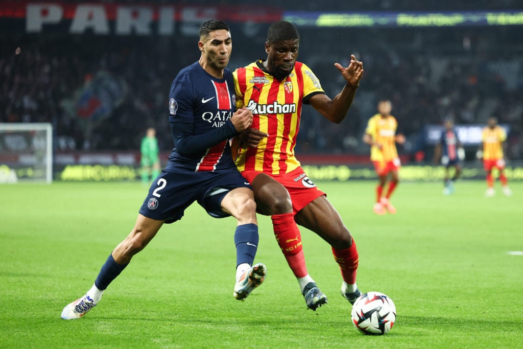 TOPSHOT - Paris Saint-Germain's Moroccan defender #02 Achraf Hakimi fights for the ball with Lens' Austrian defender #04 Kevin Danso during the Fre...