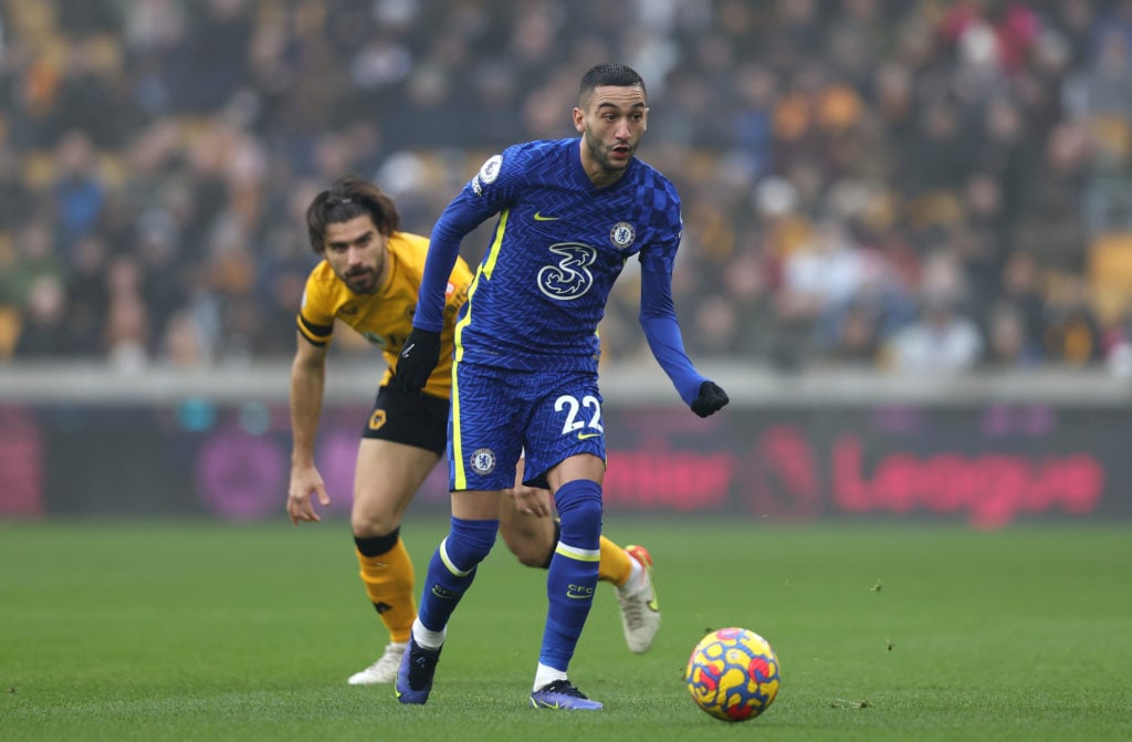 Hakim Ziyech of Chelsea runs with the ball from Ruben Neves of Wolverhampton Wanderers during the Premier League match between Wolverhampton Wander...